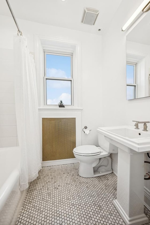 bathroom featuring radiator, toilet, and shower / bath combo with shower curtain