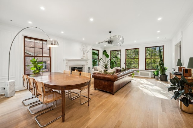 dining space with light hardwood / wood-style flooring and ornamental molding