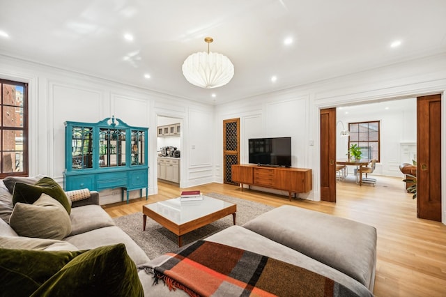 living room featuring crown molding and light hardwood / wood-style floors