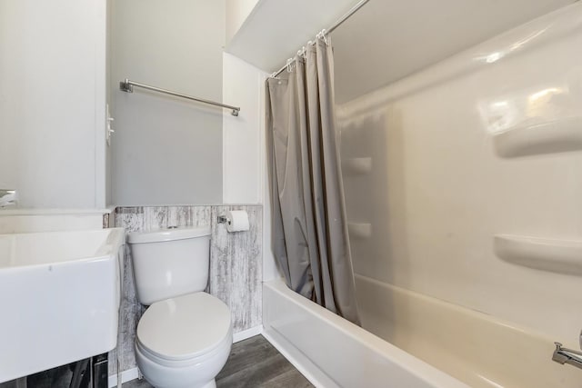 full bathroom with toilet, sink, tile walls, shower / bath combo with shower curtain, and hardwood / wood-style floors