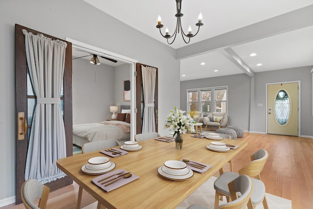 dining area featuring beamed ceiling, an inviting chandelier, and light hardwood / wood-style flooring