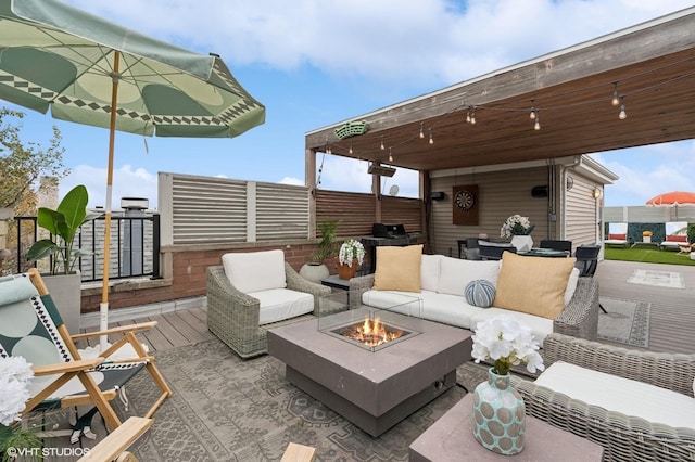 view of patio featuring an outdoor living space with a fire pit and a deck