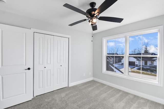 unfurnished bedroom featuring light carpet, ceiling fan, and a closet