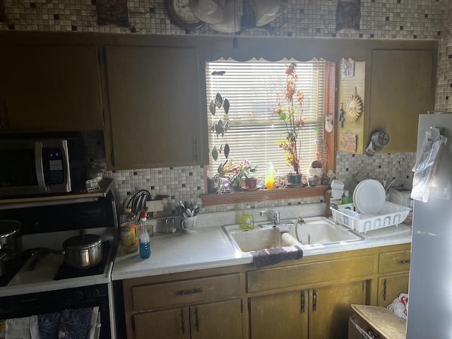 kitchen with tasteful backsplash, sink, stovetop, and oven