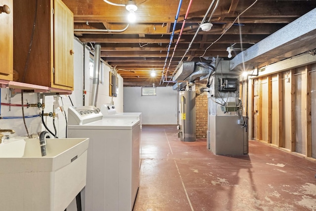 basement featuring water heater, separate washer and dryer, sink, and heating unit