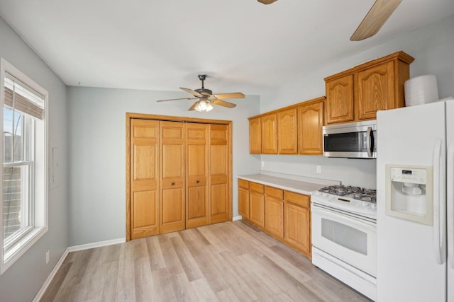 kitchen with ceiling fan, white appliances, and light hardwood / wood-style flooring