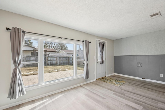 spare room with hardwood / wood-style floors and a textured ceiling