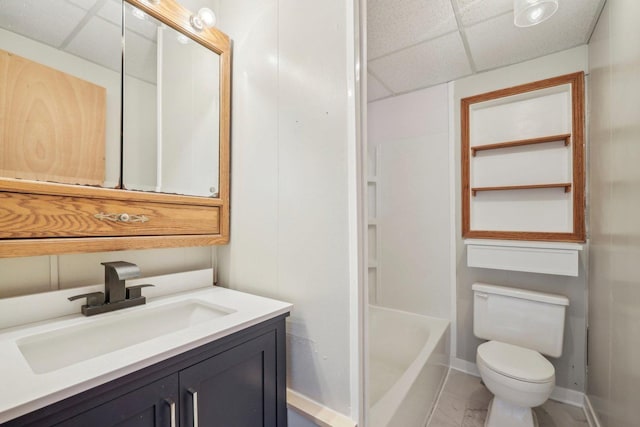 bathroom featuring a drop ceiling, vanity, and toilet