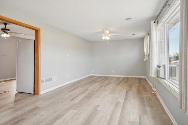 spare room featuring ceiling fan, light hardwood / wood-style floors, and a wealth of natural light
