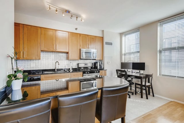 kitchen featuring tasteful backsplash, appliances with stainless steel finishes, and sink