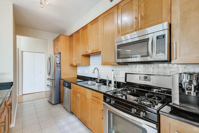 kitchen with stainless steel appliances, tasteful backsplash, sink, and dark stone countertops