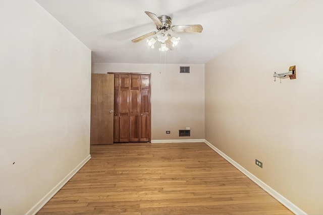 laundry area featuring ceiling fan and light hardwood / wood-style floors