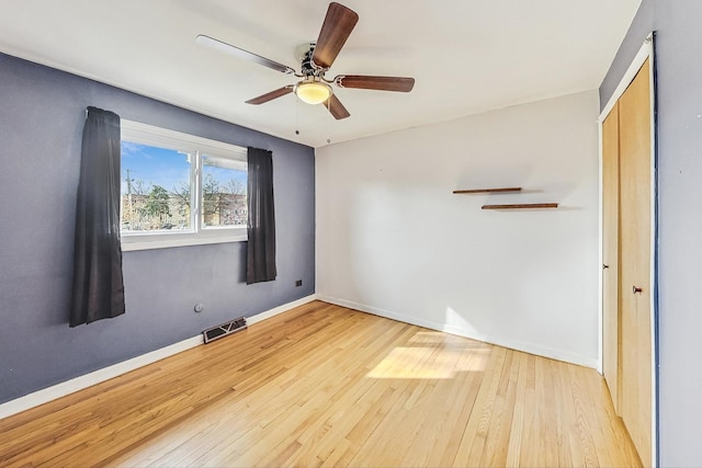 empty room with light hardwood / wood-style flooring and ceiling fan