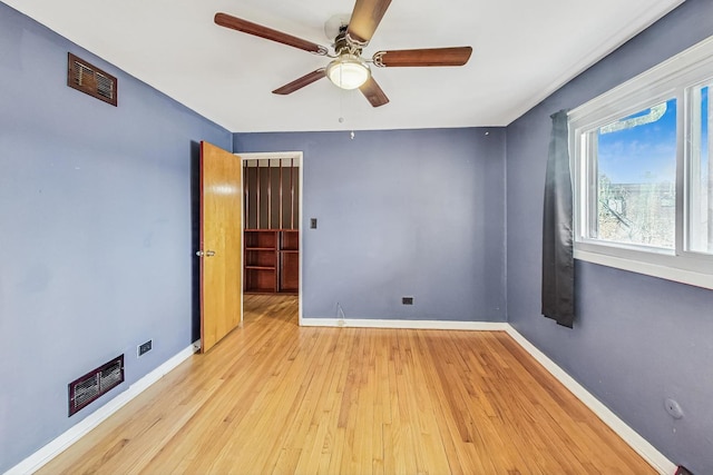 spare room with ceiling fan and light wood-type flooring