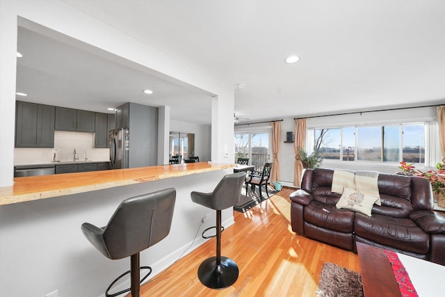 living room with sink and light wood-type flooring