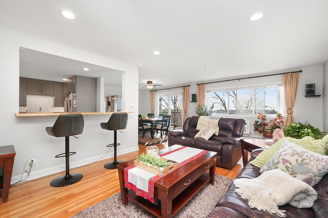 living room featuring ceiling fan, a healthy amount of sunlight, and light hardwood / wood-style flooring