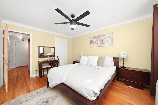 bedroom featuring crown molding, light hardwood / wood-style flooring, and ceiling fan