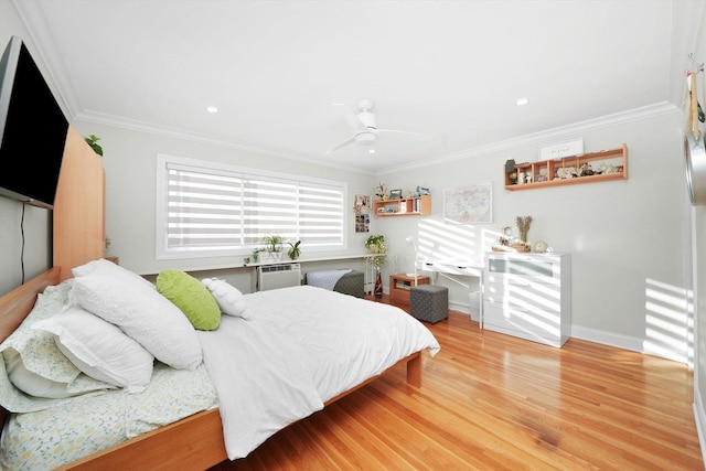 bedroom featuring ceiling fan, ornamental molding, hardwood / wood-style floors, and a wall mounted air conditioner