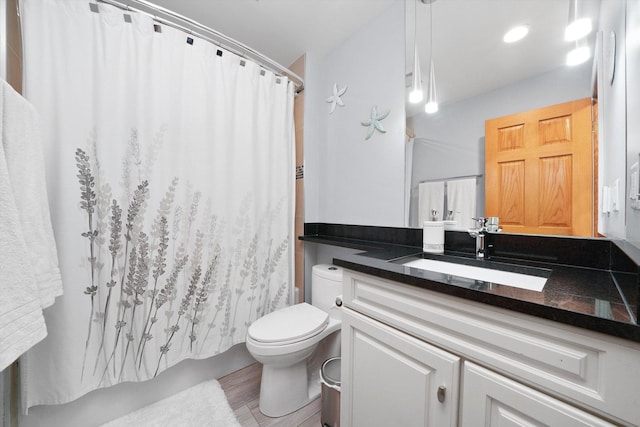 full bathroom featuring hardwood / wood-style flooring, vanity, shower / bath combo with shower curtain, and toilet