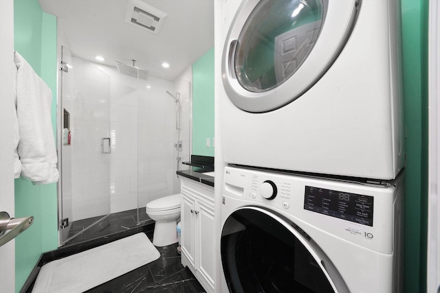 bathroom featuring walk in shower, stacked washer and clothes dryer, toilet, and vanity