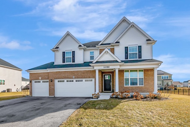 view of front of property with central AC unit, a garage, and a front yard