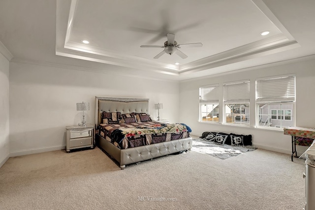 bedroom featuring crown molding, ceiling fan, a tray ceiling, and light carpet