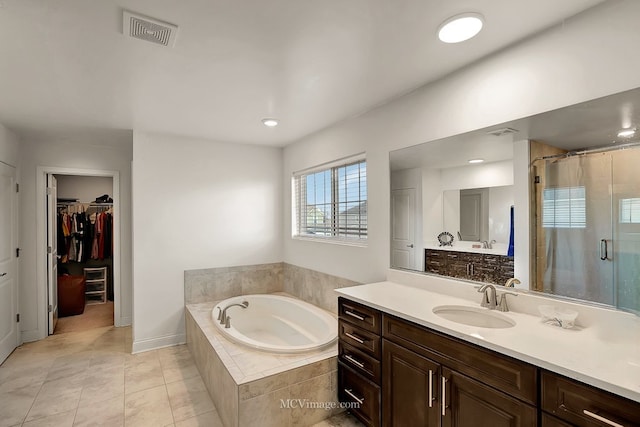 bathroom featuring independent shower and bath, vanity, and tile patterned flooring