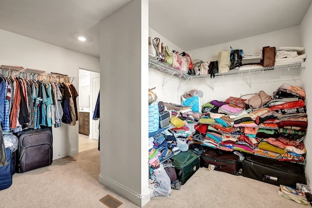 walk in closet featuring light colored carpet