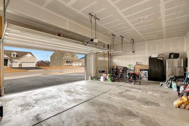 garage featuring a garage door opener and stainless steel fridge