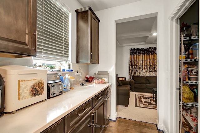 interior space featuring beamed ceiling, dark brown cabinetry, and dark hardwood / wood-style flooring