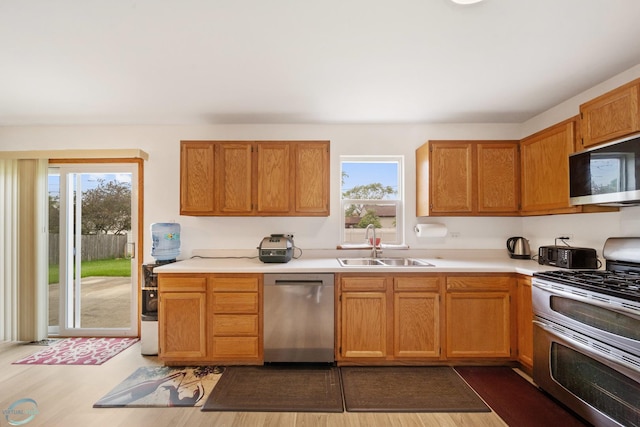 kitchen with appliances with stainless steel finishes, sink, and dark hardwood / wood-style floors