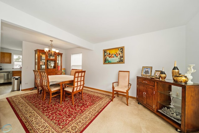 carpeted dining area featuring a notable chandelier and sink