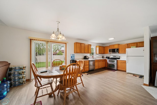 dining space featuring an inviting chandelier and light hardwood / wood-style floors