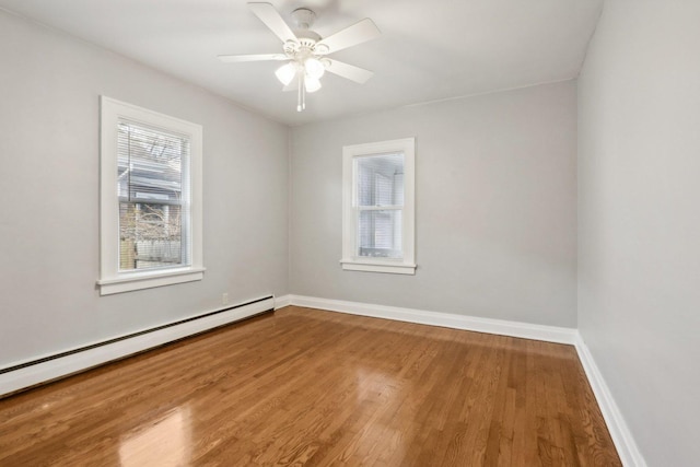 empty room with hardwood / wood-style flooring, a baseboard radiator, and ceiling fan