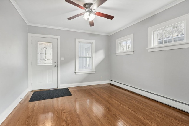 foyer with baseboard heating, ceiling fan, crown molding, and hardwood / wood-style floors