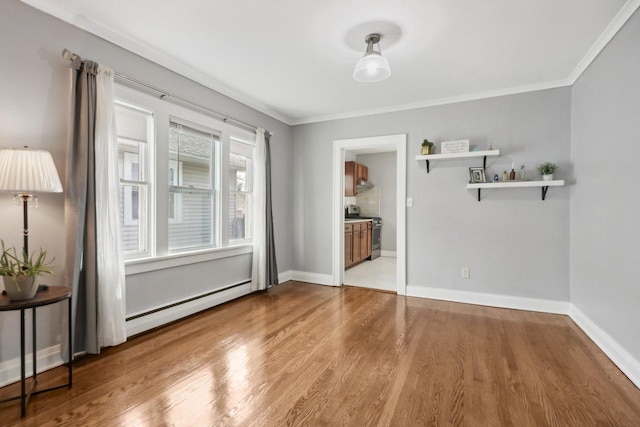 unfurnished room with baseboard heating, ornamental molding, and wood-type flooring