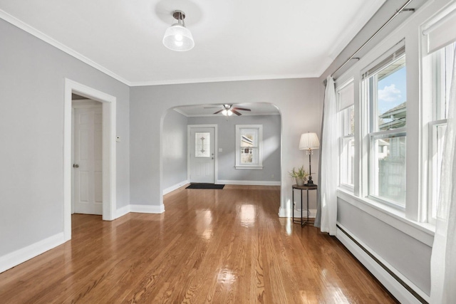 foyer featuring a baseboard heating unit, crown molding, hardwood / wood-style floors, and ceiling fan