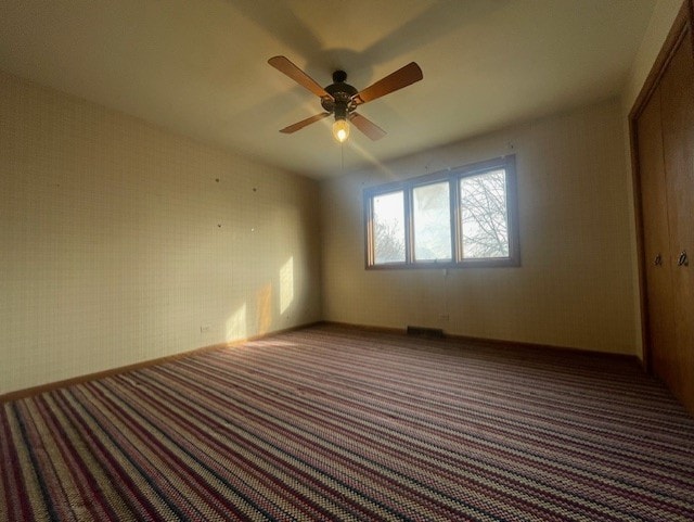 carpeted empty room featuring ceiling fan