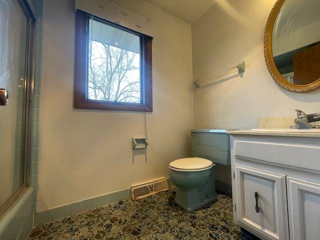 full bathroom with vanity, shower / bath combination with glass door, and toilet