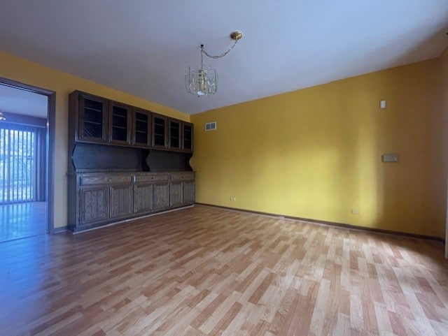 interior space with a notable chandelier and light wood-type flooring