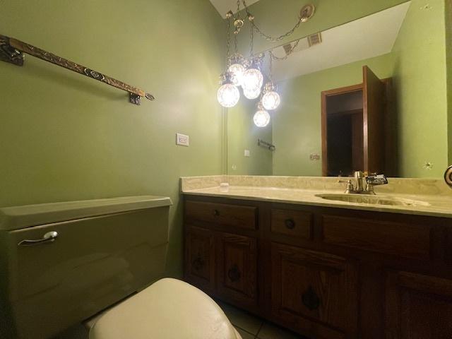 bathroom featuring vanity, vaulted ceiling, and toilet