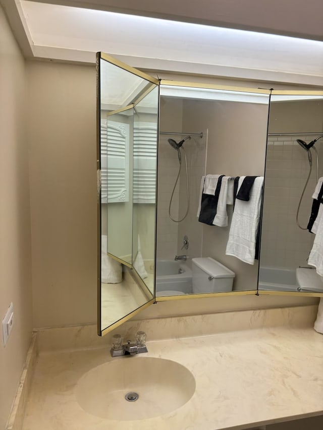 full bathroom featuring tiled shower / bath, vanity, and toilet