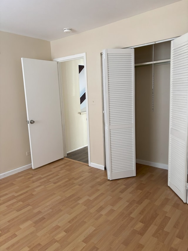 unfurnished bedroom with light hardwood / wood-style flooring and a closet