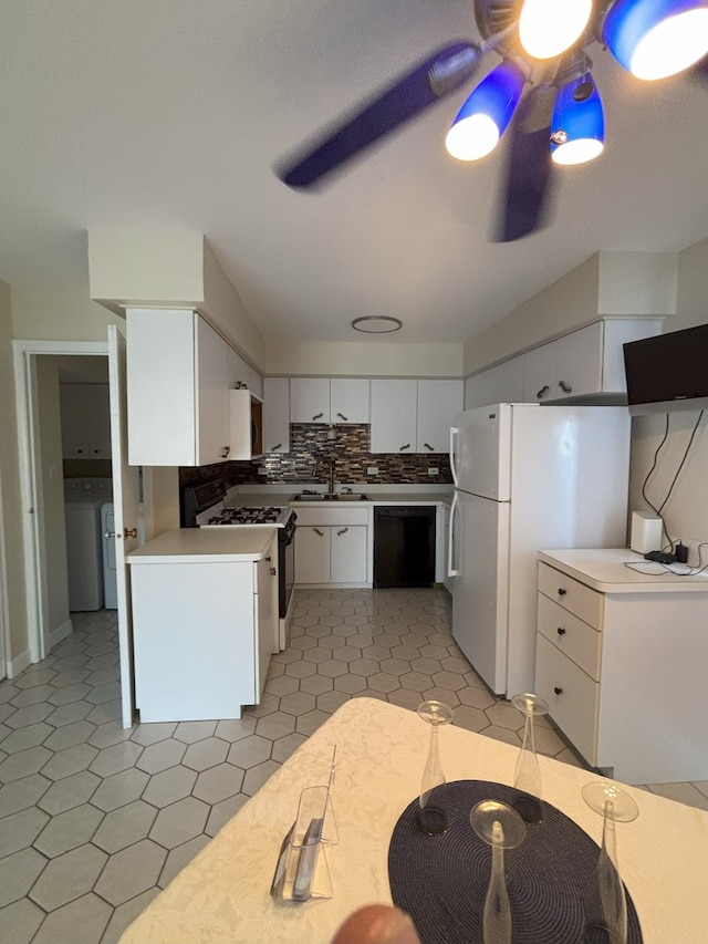 kitchen with sink, range with gas cooktop, black dishwasher, washer / clothes dryer, and white cabinets