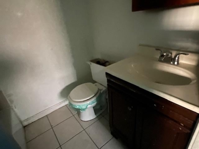 bathroom featuring tile patterned flooring, vanity, and toilet