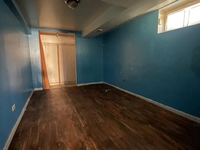 unfurnished bedroom with dark hardwood / wood-style flooring and a closet