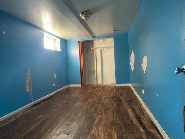 unfurnished bedroom featuring hardwood / wood-style floors and a closet