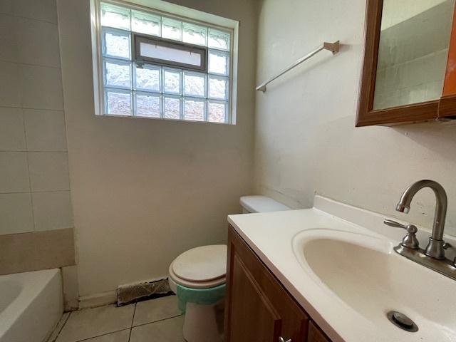 bathroom featuring vanity, tile patterned floors, toilet, and a bathing tub