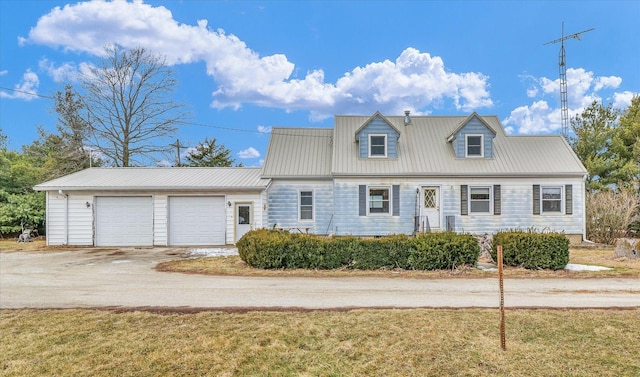 cape cod home featuring a garage and a front yard