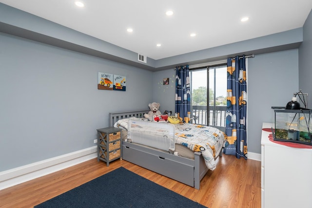 bedroom featuring hardwood / wood-style flooring and access to exterior